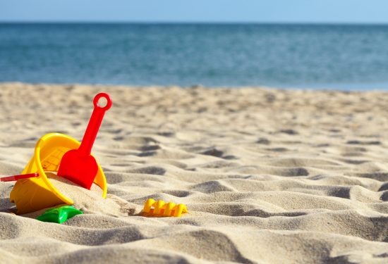 Sandbox toys at the beach under blue sky